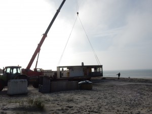 Kran hat Baucontainer an der Leine - Saisonende auf Texel